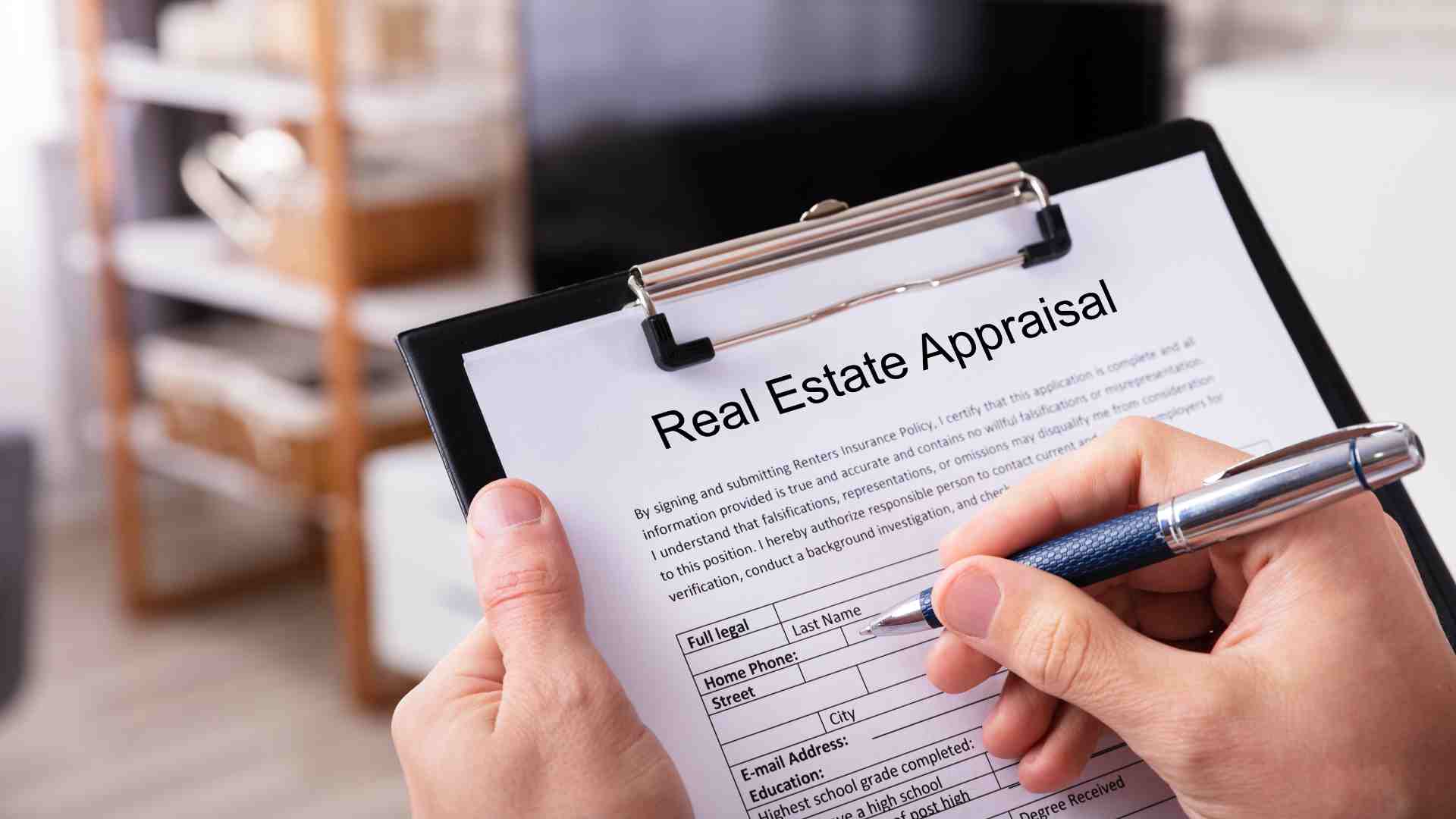 A person holds a clipboard with a "Real Estate Appraisal" form, diligently filling out a section with a pen. The background shows indistinct indoor items, illustrating their thorough understanding of home appraisals.