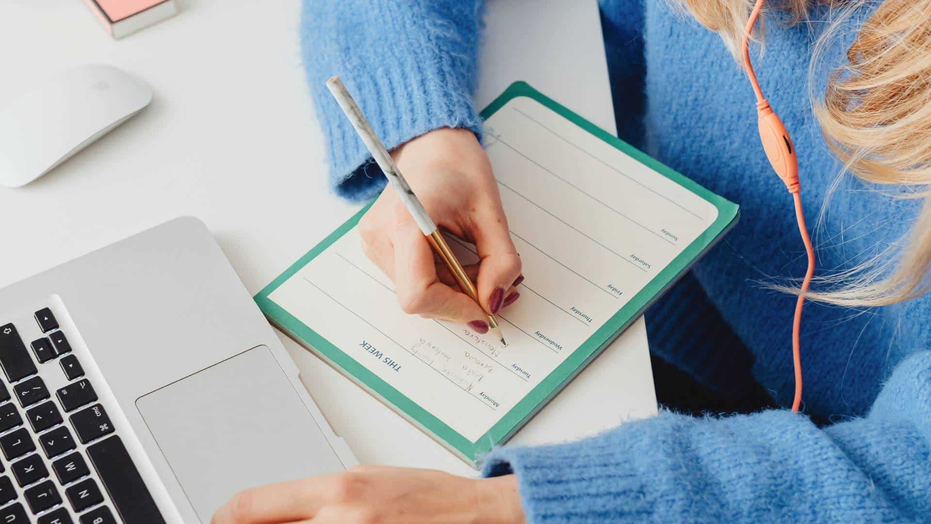 home maintenance checklist woman planning a trip or activity at laptop