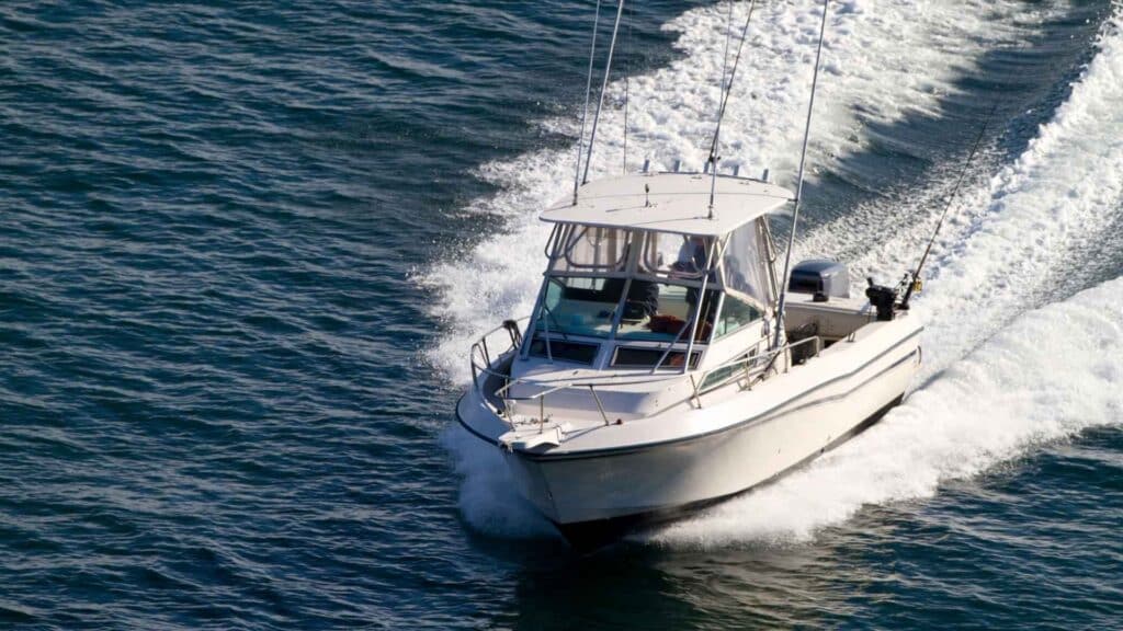 white fishing boat sailing through the open blue sea