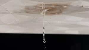 dirty wet ceiling stain dripping with black background