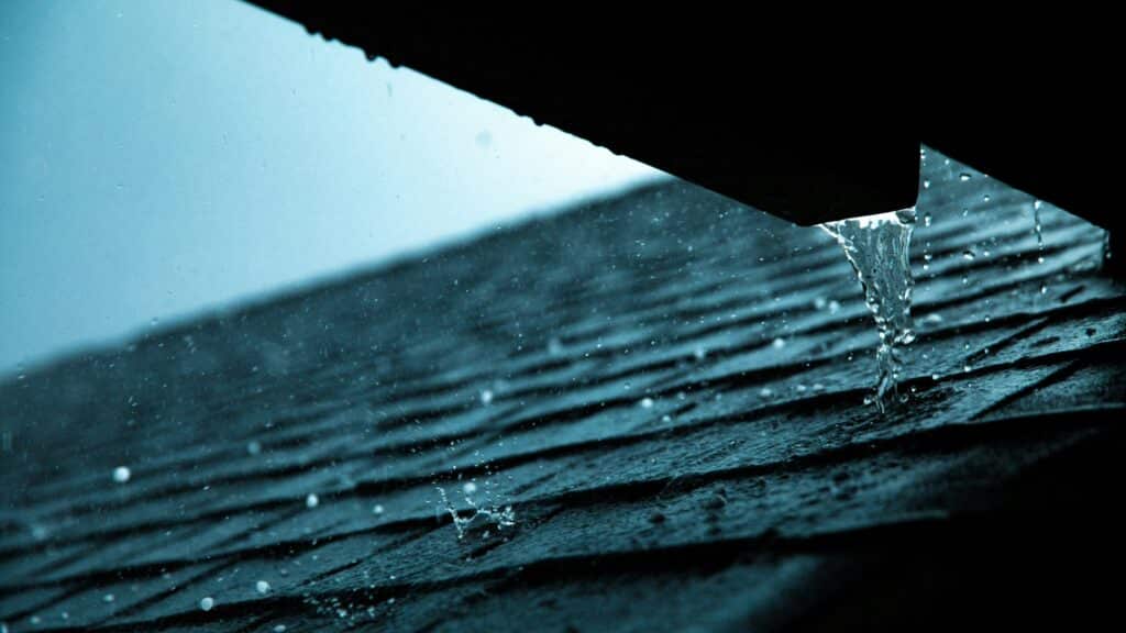 rain pouring down a shingle roof