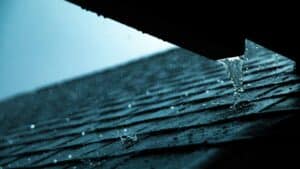 rain pouring down a shingle roof
